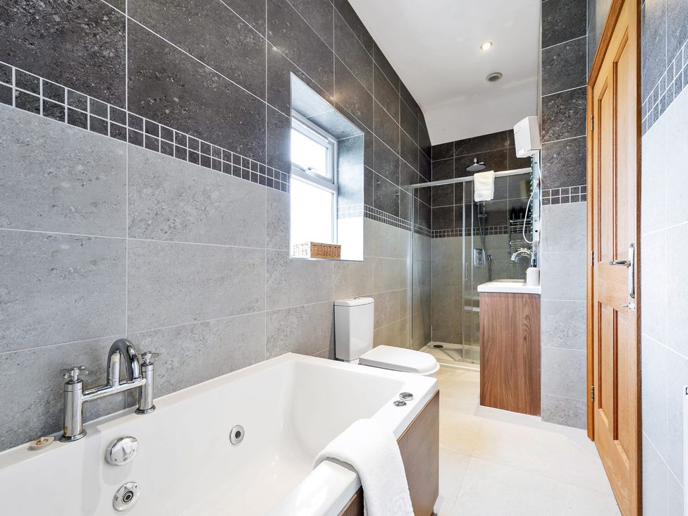 A bathroom featuring a bathtub, toilet, shower, and sink at Oldfields