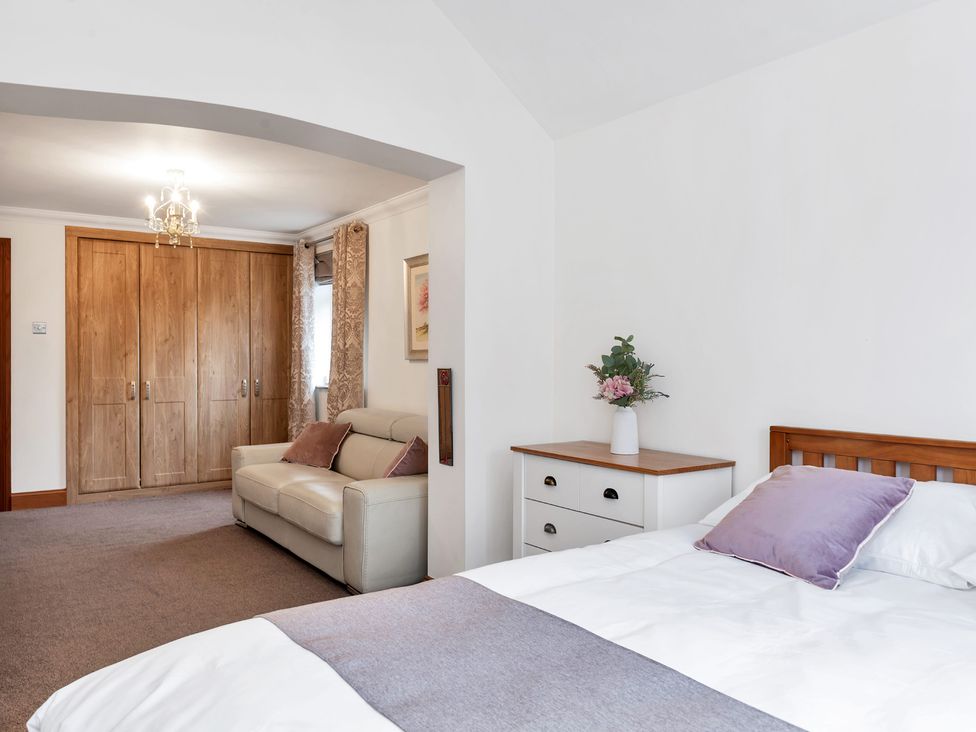 A bedroom with a bed, sofa, and wardrobe at Oldfields