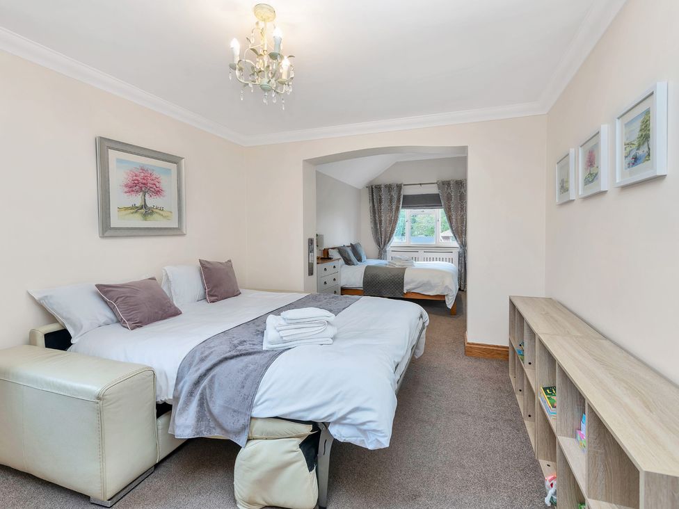 A bedroom with two beds and a bookcase at Oldfields