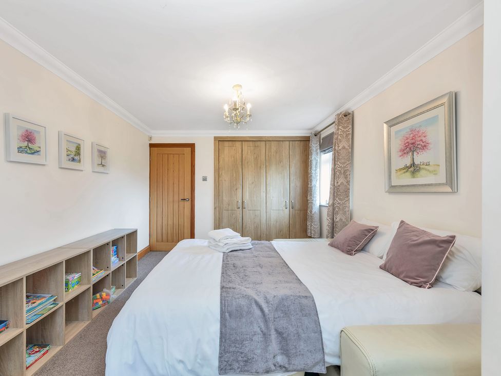 A bedroom with a bed and shelving at Oldfields