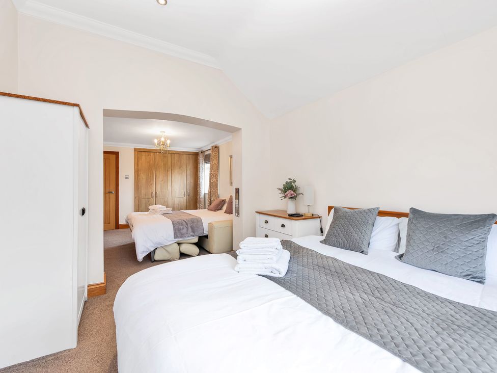 A bedroom with two beds and a wardrobe at Oldfields