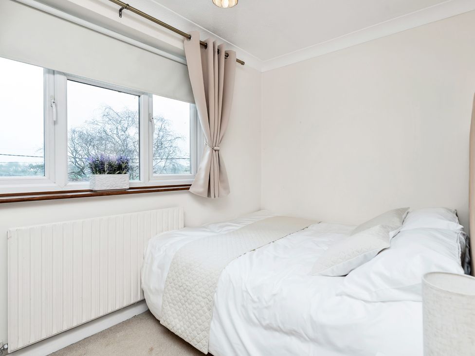 A bedroom with a bed and windows at Oldfields