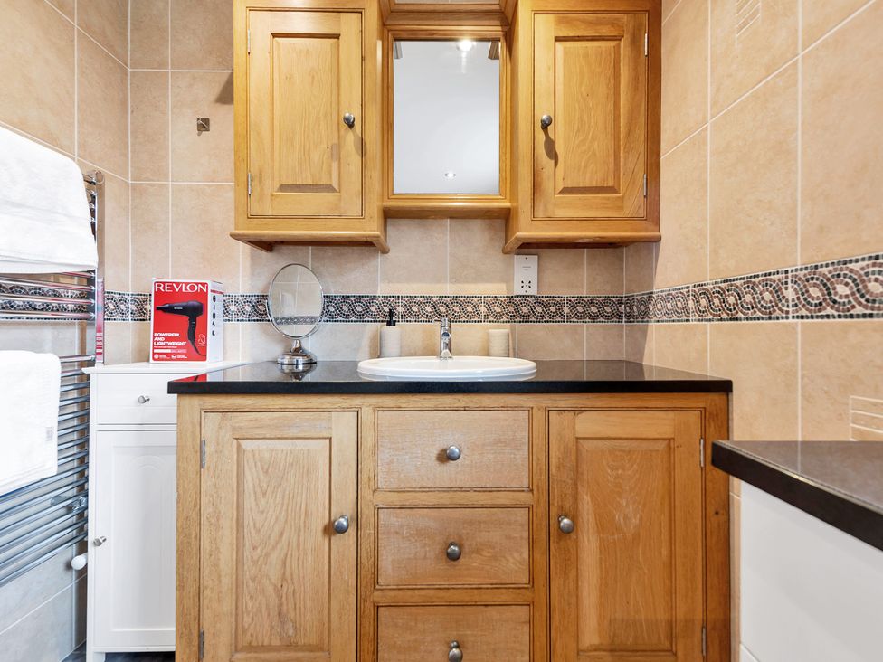 A bathroom with a sink and wooden cabinets at Oldfields