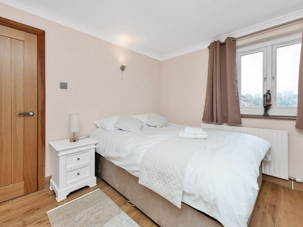 A bedroom with a bed and bedside table at Oldfields
