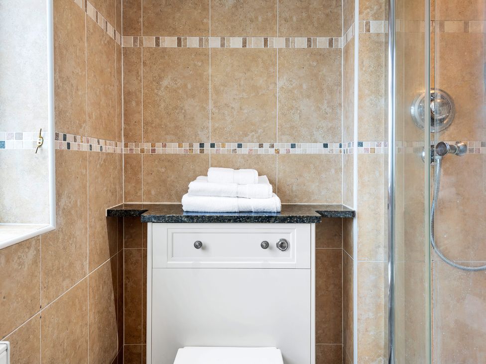 A bathroom with towels on a counter and a shower at Oldfields