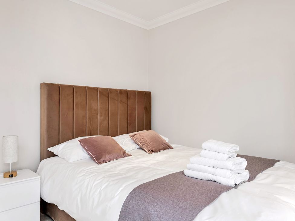 A bedroom with a bed and towels on the side at Oldfields