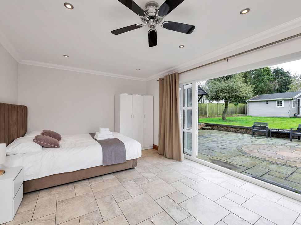 A bedroom with a bed and sliding door access to the outside at Oldfields