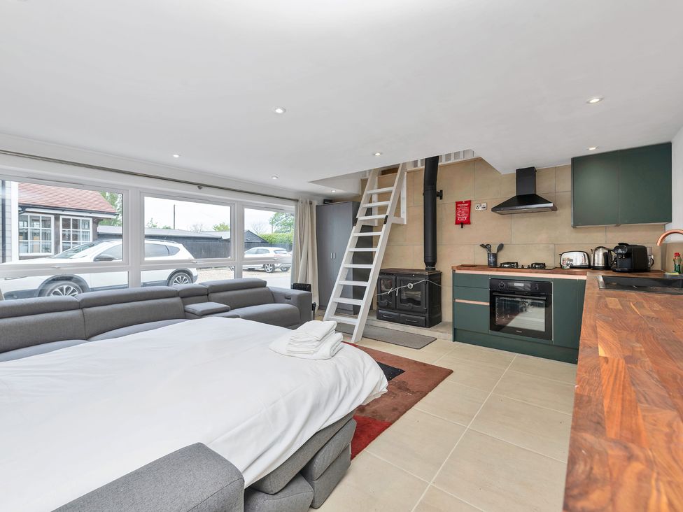 A living room with a sofa and kitchen area at Oldfields