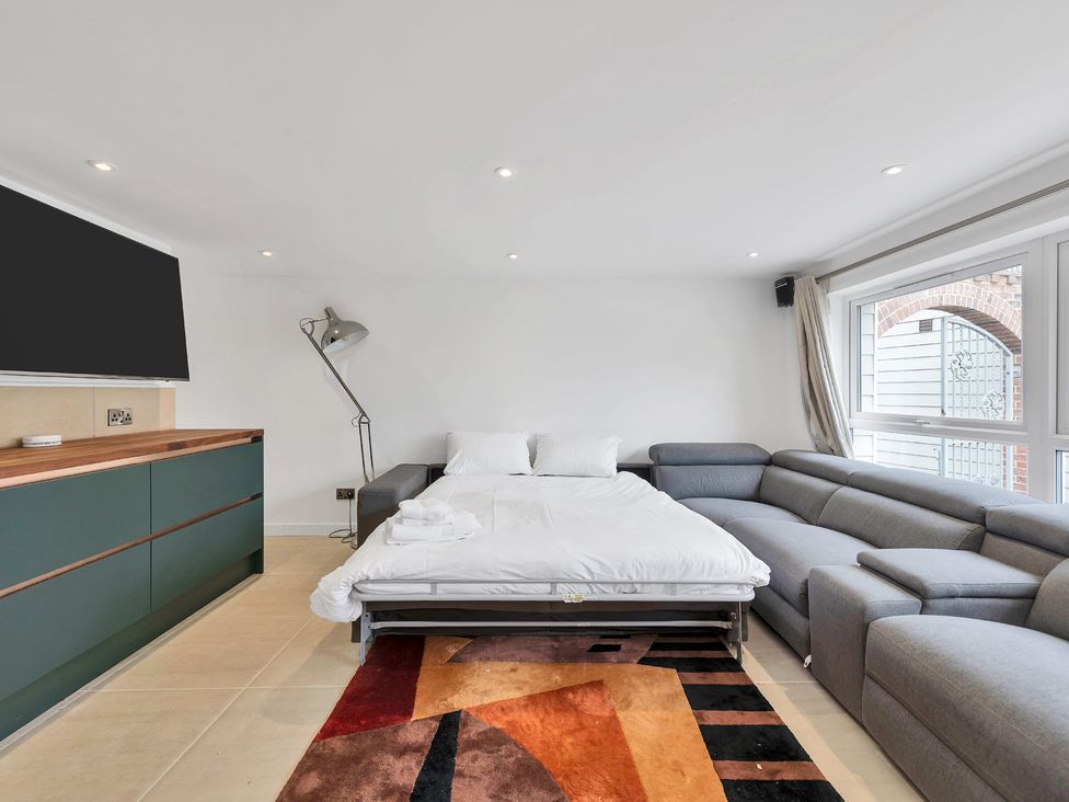 A living room with a sofa bed and cabinet at Oldfields