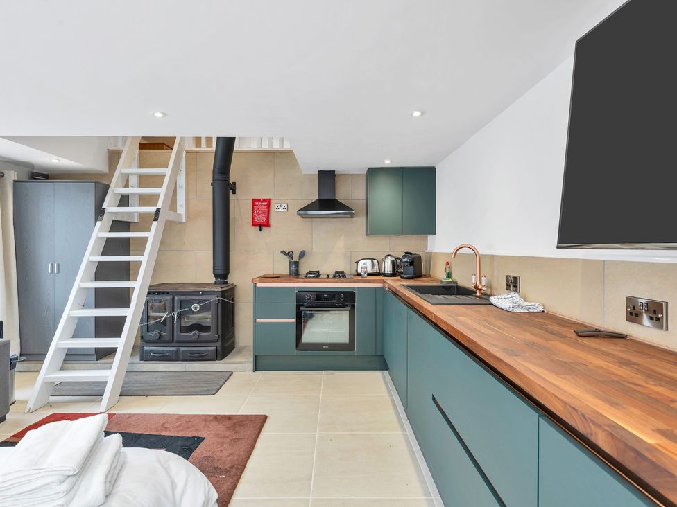 A kitchen with appliances and a ladder at Oldfields