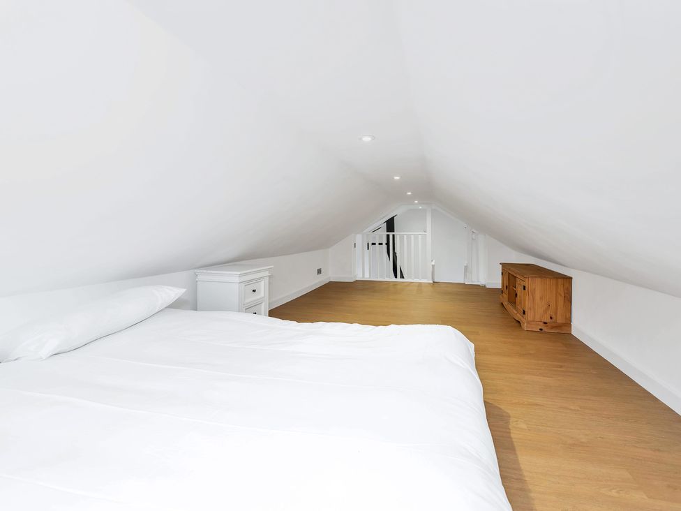 A loft with a bed, nightstand, and wooden chest at Oldfields