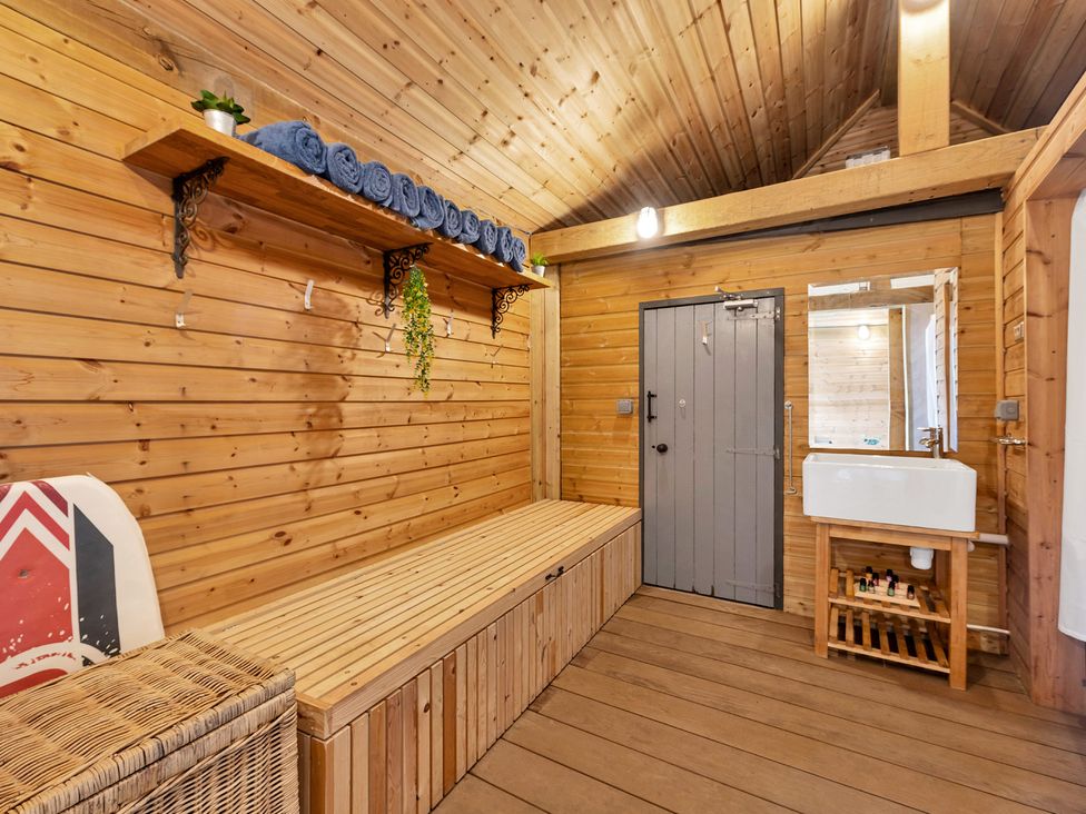 A bathroom with a sink and towels on shelves at Oldfields