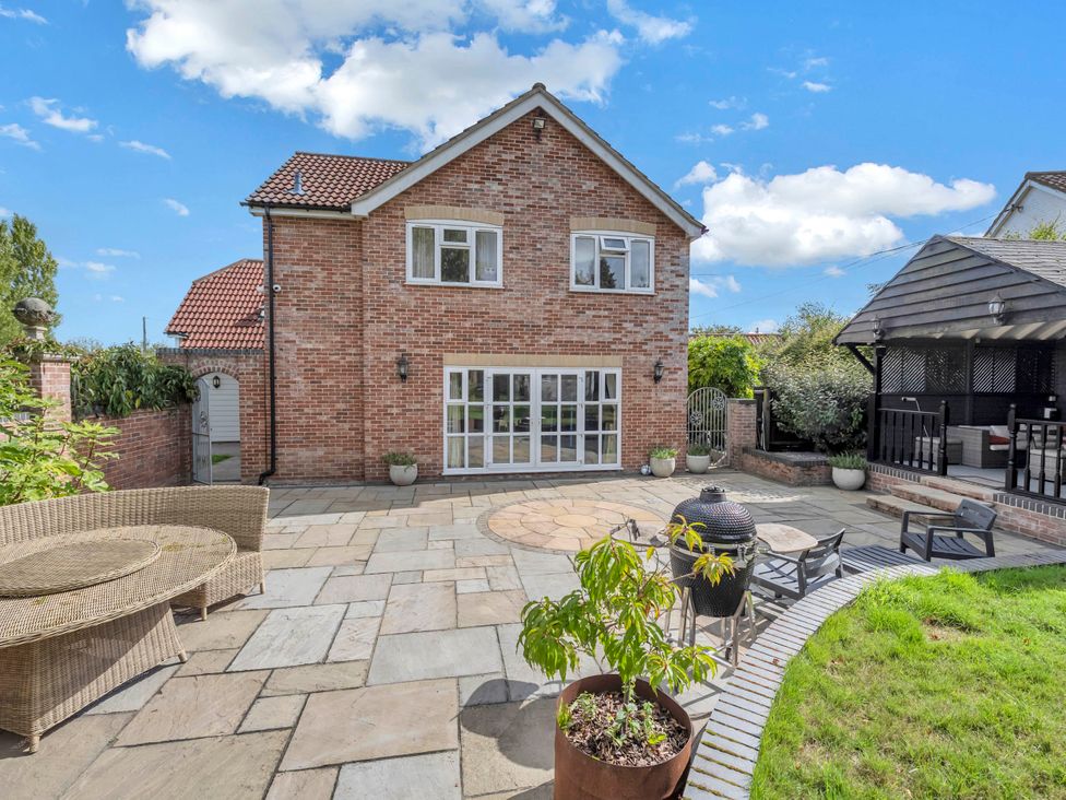 A brick house with a patio and garden at Oldfields in Bury St Edmunds