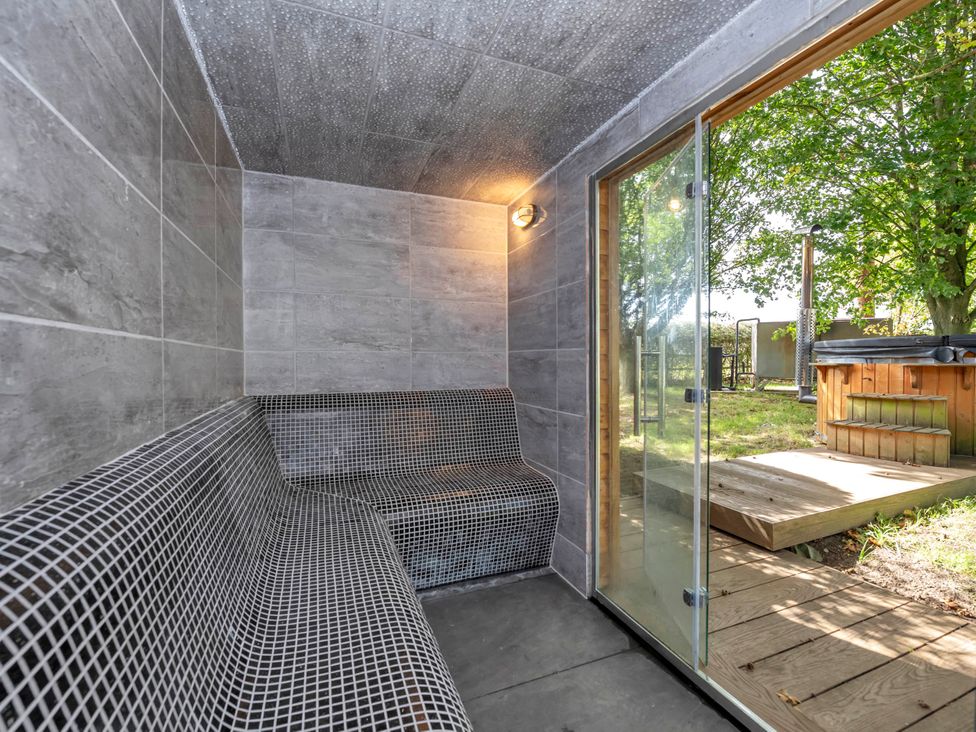 A sauna with bench and glass door at Oldfields Bury St Edmunds