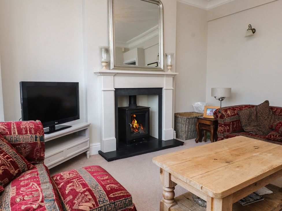 A living room with a fireplace and television at Bryniau in Pwllheli