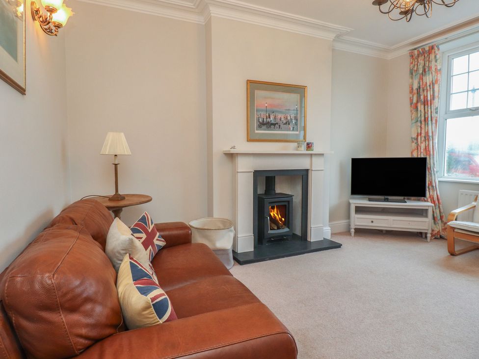 A living room with a fireplace and television at Bryniau in Pwllheli