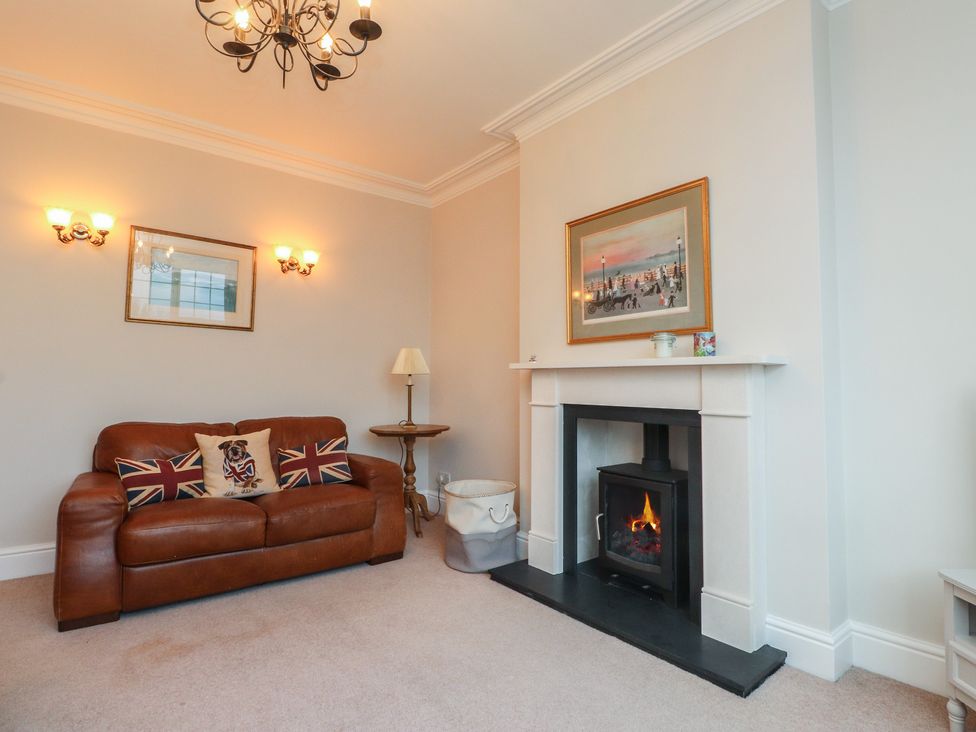 A living room with a sofa and fireplace at Bryniau in Pwllheli