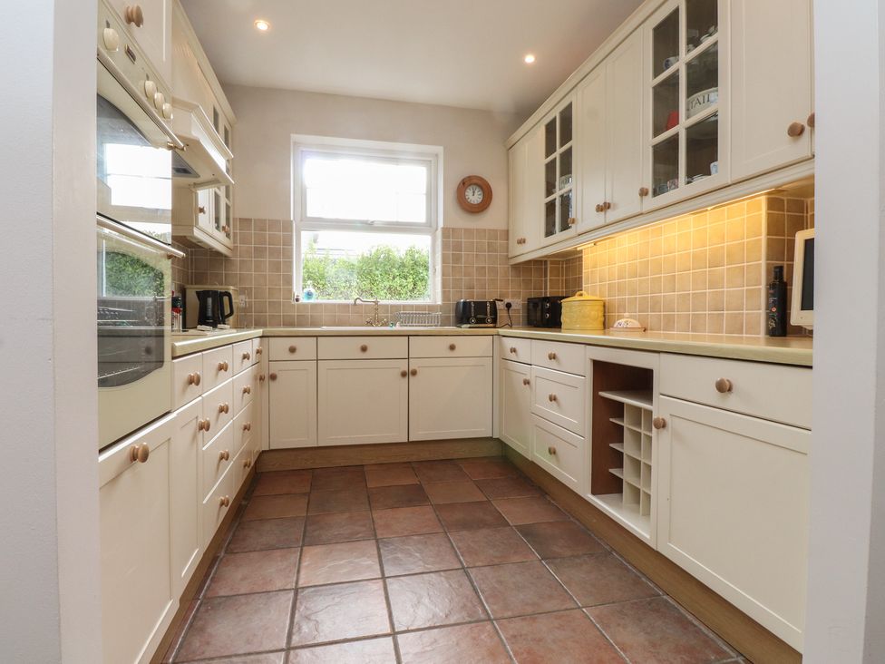 A kitchen with cabinets, countertop, and appliances at Bryniau in Pwllheli