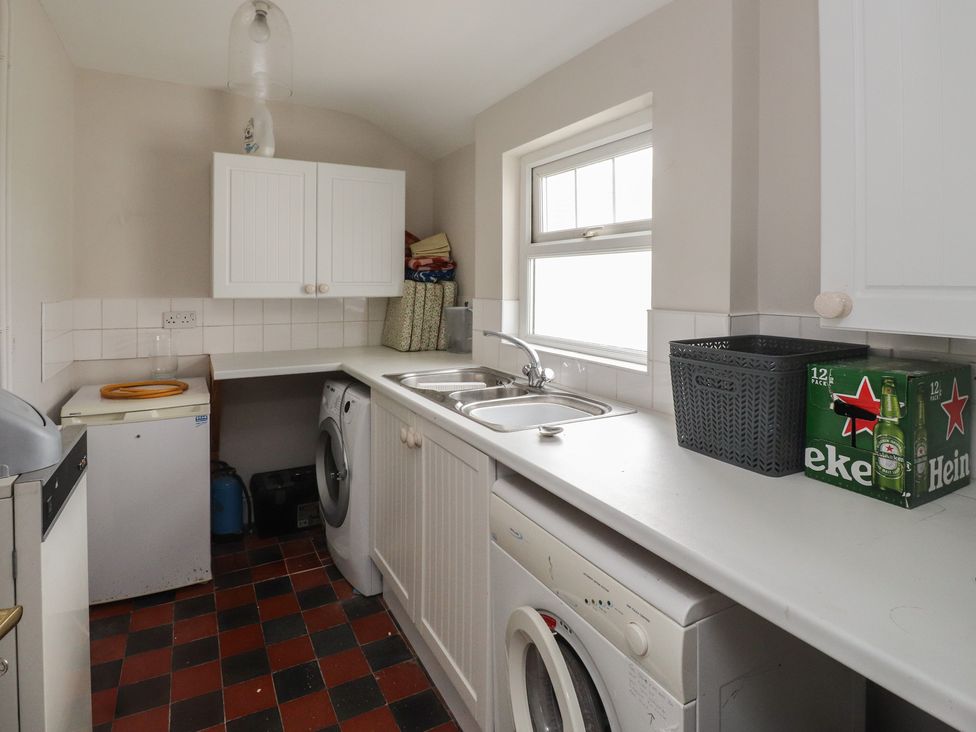 A laundry room with a sink and washing machine at Bryniau in Pwllheli