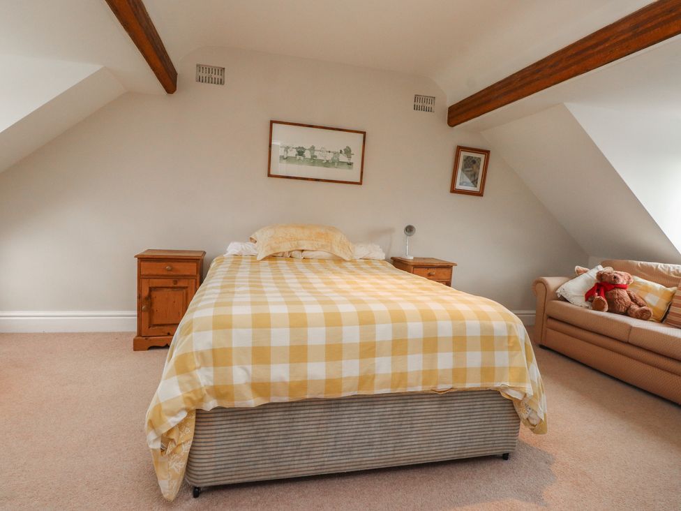 A bedroom with a bed and bedside table at Bryniau in Pwllheli