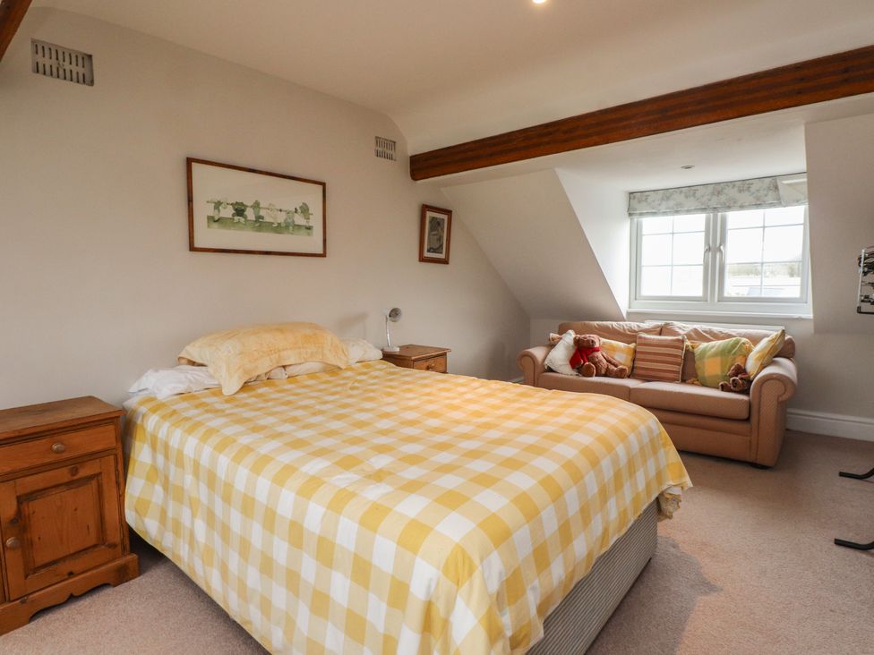 A bedroom with a bed and a sofa at Bryniau in Pwllheli
