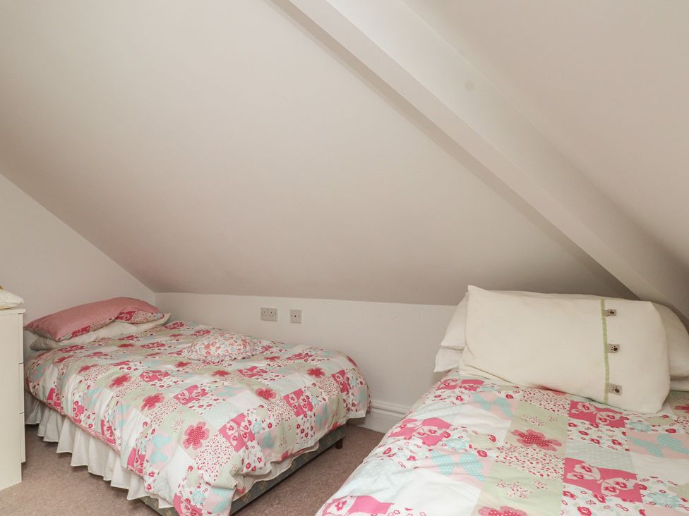 A bedroom with two beds placed side by side at Bryniau in Pwllheli