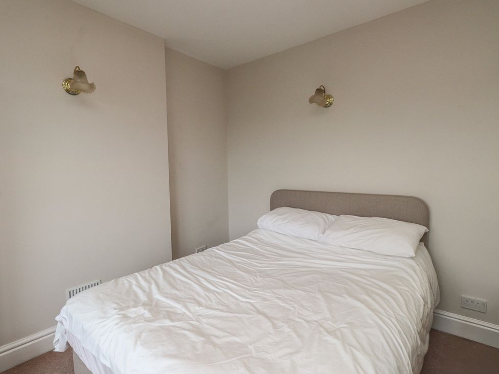 A bedroom with a bed and light fixtures at Bryniau Pwllheli