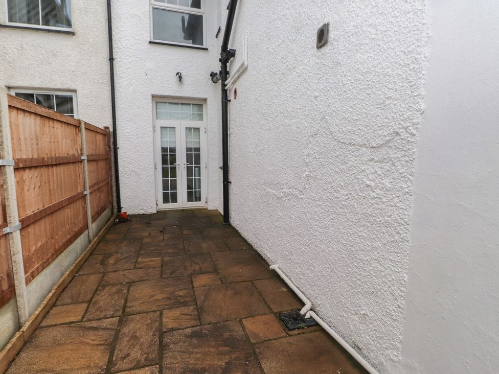 An outdoor area with a stone pathway and a door at Bryniau Pwllheli