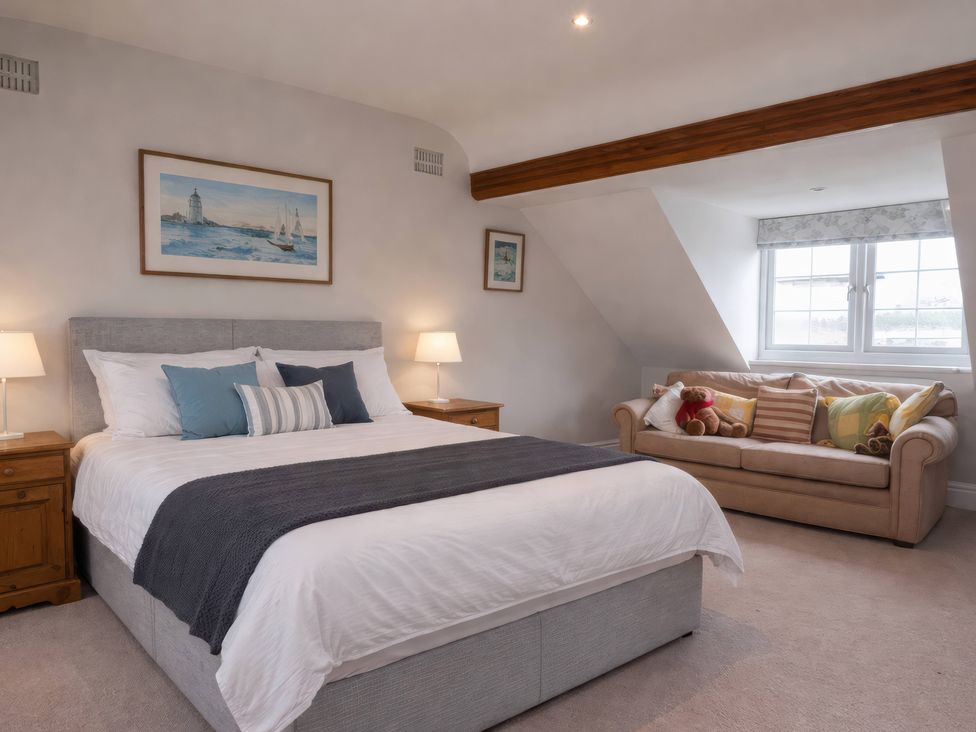 A bedroom with a bed and a couch at Bryniau in Morfa Nefyn