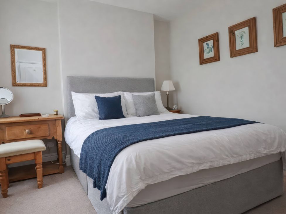 A bedroom with a bed and dressing table at Bryniau in Morfa Nefyn