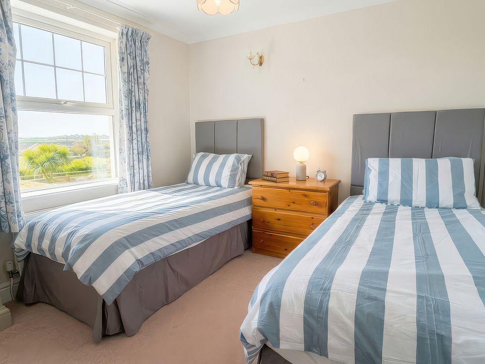 A bedroom with two beds and a window at Bryniau in Morfa Nefyn