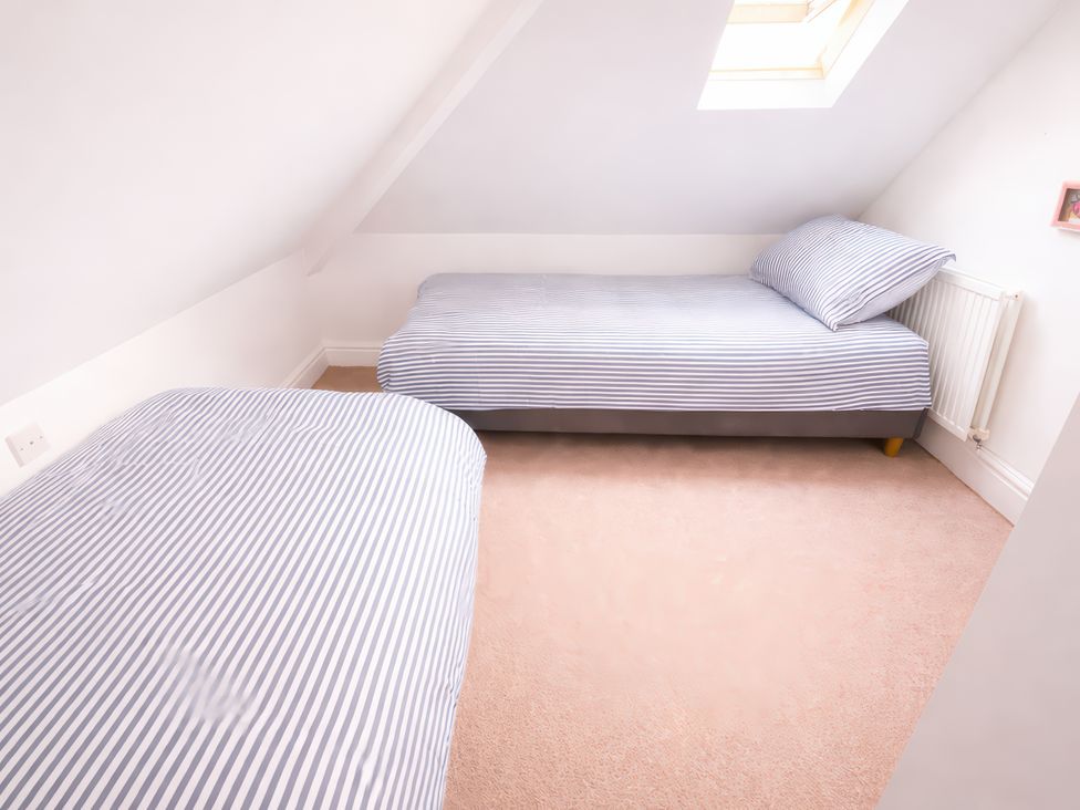 A bedroom with two beds and a skylight at Bryniau in Morfa Nefyn