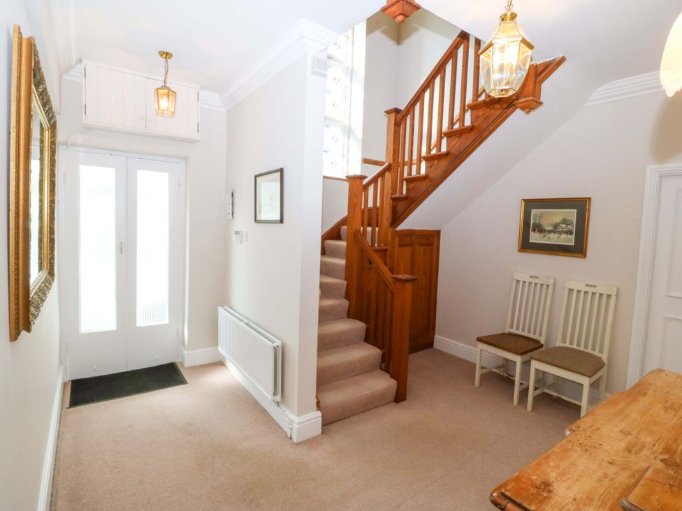 A hallway with stairs and a table at Bryniau in Morfa Nefyn
