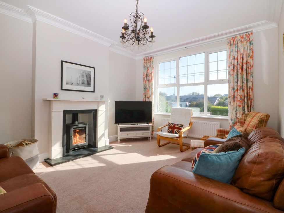 A living room with a fireplace and television at Bryniau in Morfa Nefyn