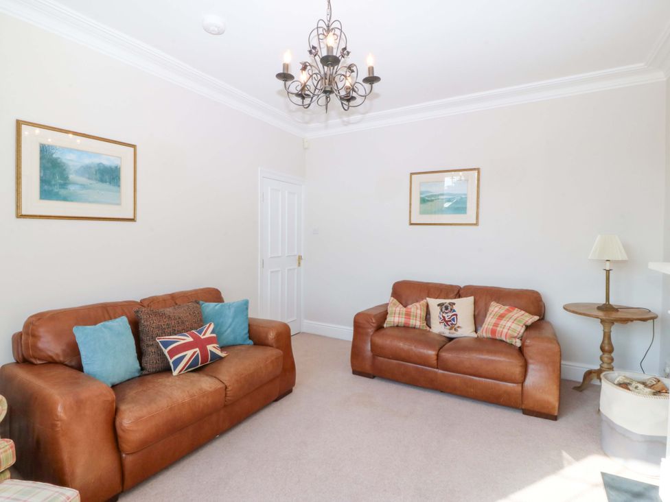 A living room with leather sofas and a coffee table at Bryniau in Morfa Nefyn