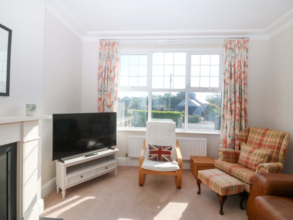 A living room with a television and armchair at Bryniau Morfa Nefyn