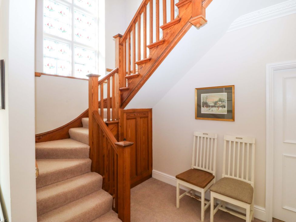 A staircase and two chairs in a hallway at Bryniau Morfa Nefyn