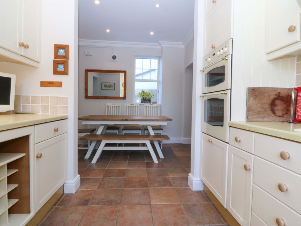 A kitchen with a dining table and appliances at Bryniau in Morfa Nefyn