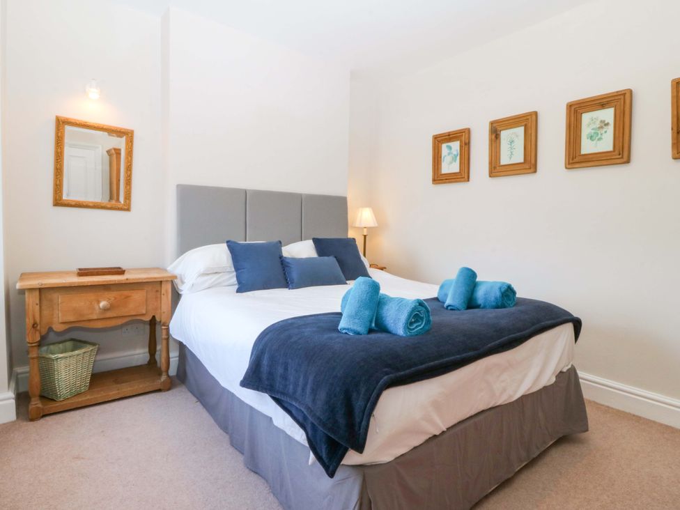 A bedroom with a bed and framed pictures on the wall at Bryniau in Morfa Nefyn