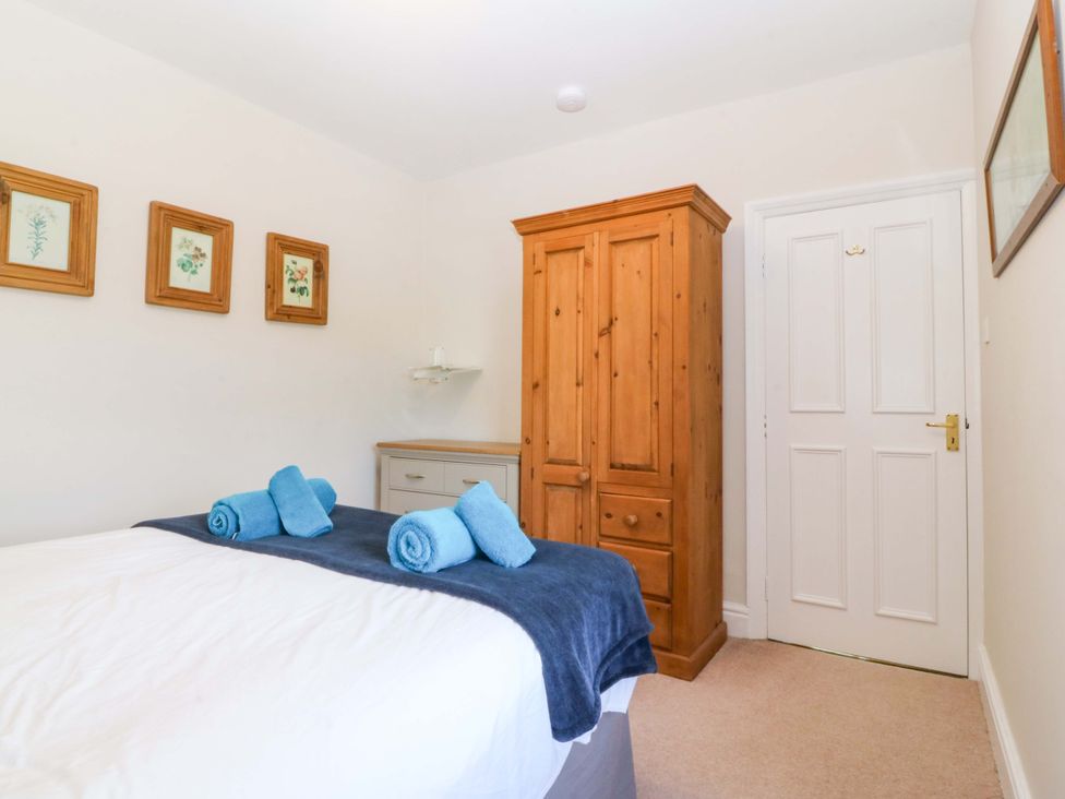 A bedroom with a bed and wardrobe at Bryniau Morfa Nefyn