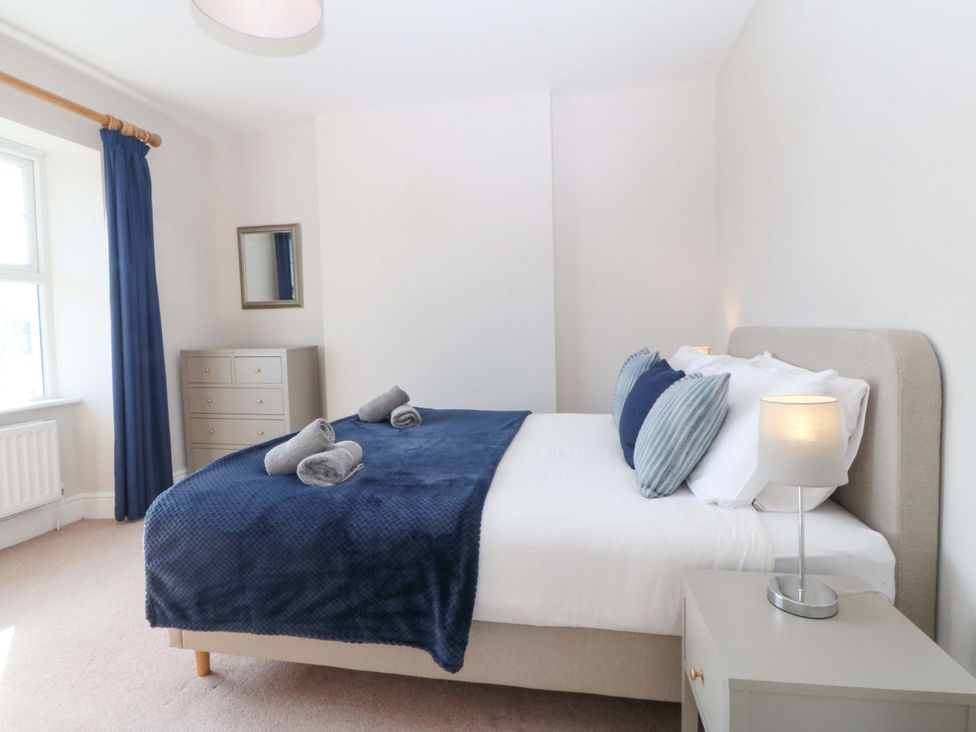 A bedroom with a bed and dresser at Bryniau in Morfa Nefyn