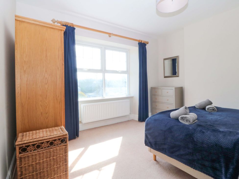 A bedroom with a bed, wardrobe, and dresser at Bryniau in Morfa Nefyn