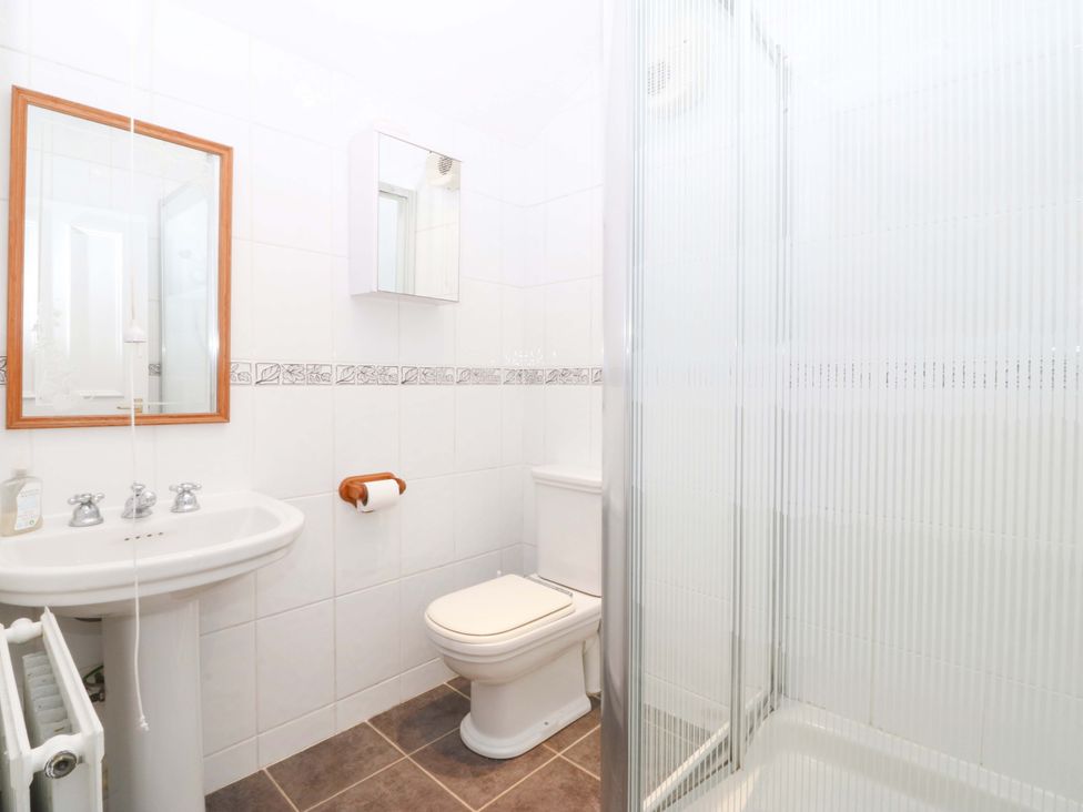 A bathroom with a sink, toilet, and shower at Bryniau in Morfa Nefyn