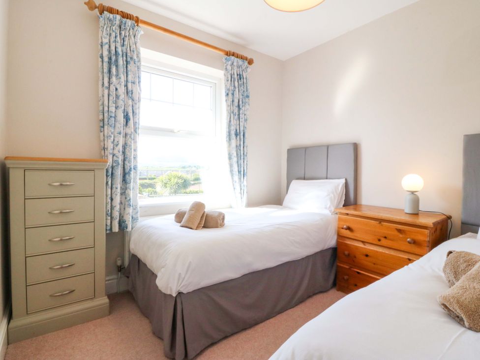 A bedroom with two beds and a drawer unit at Bryniau Morfa Nefyn