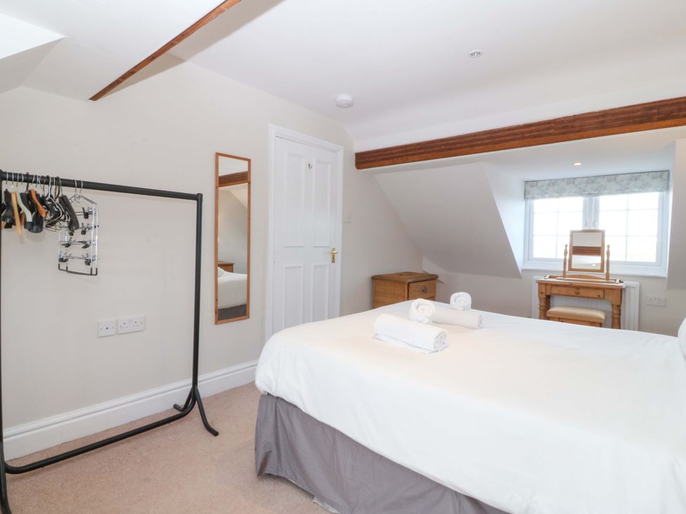 A bedroom with a bed and mirror at Bryniau in Morfa Nefyn