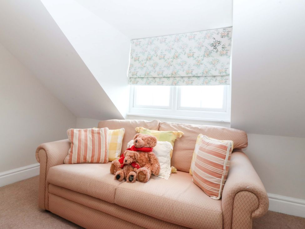 A snug with a sofa and teddy bear at Bryniau in Morfa Nefyn