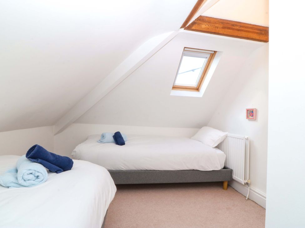 A bedroom with two single beds and a window at Bryniau in Morfa Nefyn