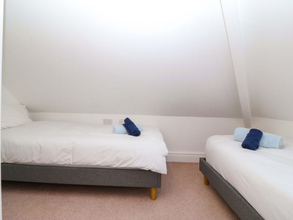 A bedroom with two single beds and towels at Bryniau in Morfa Nefyn