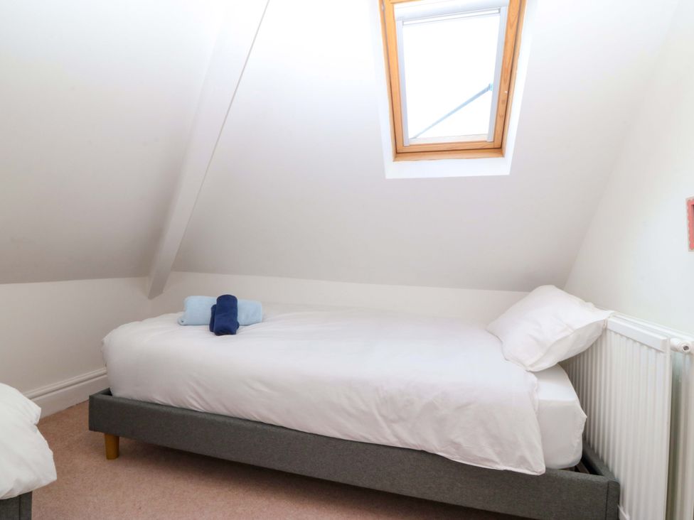 A bedroom with a single bed and a window at Bryniau in Morfa Nefyn