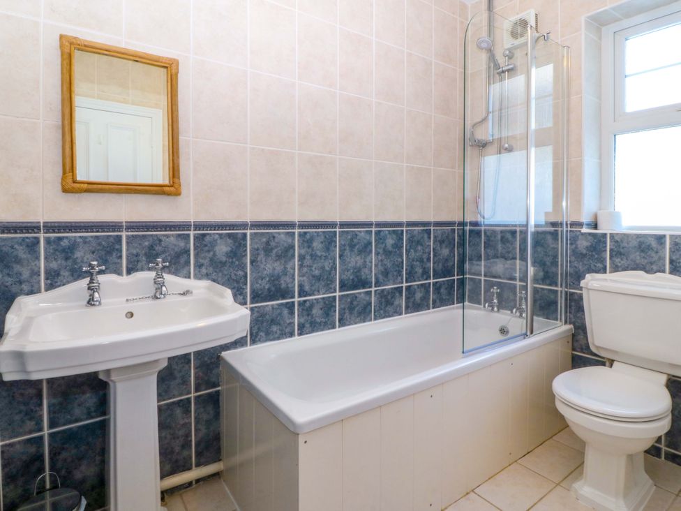 A bathroom with a bathtub and shower at Bryniau Morfa Nefyn